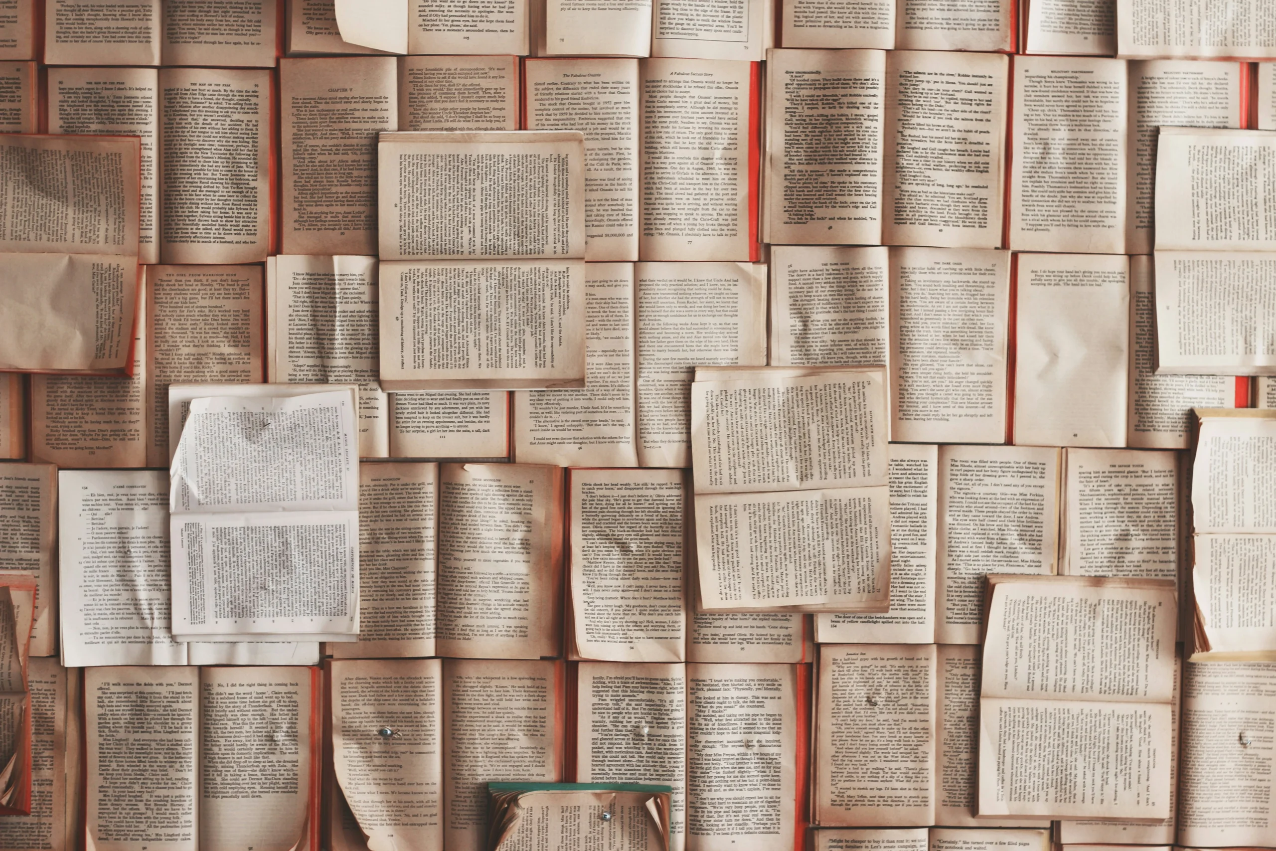 many books laying on the floor, many pages flows because of winds