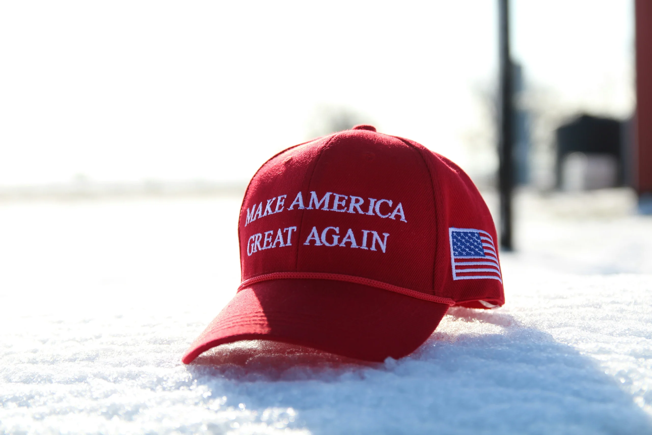 A red cap with the slogan "Make America Great Again," reflecting the significant impact of Trump's policies on American society, nation, and the world.